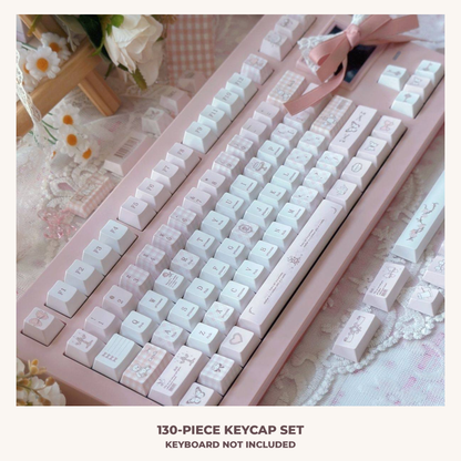 Love-themed pink and white keycaps in a styled desk setting; keyboard and accessories not included.